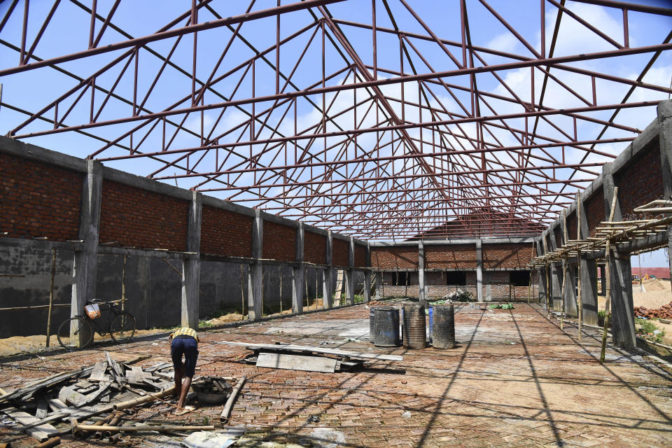 In this Aug.29, 2019 photo, a laborer works on an under-construction building intended to function as detention center for people who are not included in the National Register of Citizens, (NRC) in Kadamtola Gopalpur village, in Goalpara district, in Assam, India. Nearly 2 million people, about half Hindu and half Muslim, were excluded from NRC, an official list of citizens and have been asked to prove their citizenship or else be considered foreign. India is building the detention center for some of the tens of thousands of people who the courts are expected to ultimately determine have entered illegally. (AP Photo)