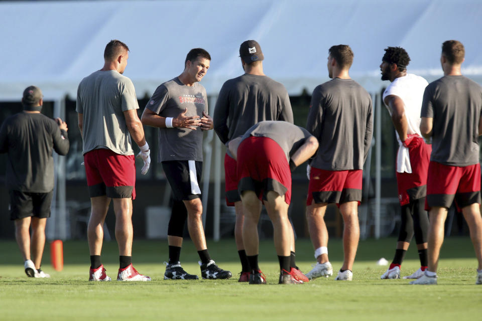 Tampa Bay Buccaneers quarterback Tom Brady, third from left, joins his teammates at midfield during NFL football training camp, Tuesday, Aug. 4, 2020, in Tampa. (Douglas R. Clifford/Tampa Bay Times via AP)