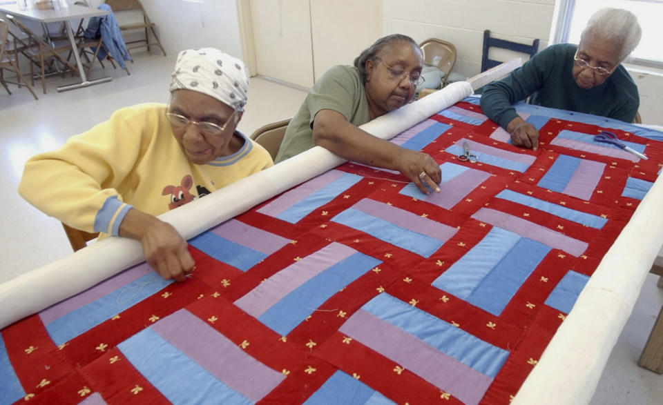 FILE - Gee's Bend Quilters, from left, Lucy Marie Mingo, Nancy Pettway and Arlonzia Pettway work on a quilt in the Boykin nutrition center in Boykin, Ala., April 6, 2006. Target launched a limited-edition collection based on the Gee’s Bend quilters' designs for Black History Month in 2024. The Target designs were “inspired by” five Gee's Bend quilters who reaped limited financial benefits from the collection’s success. (Bernard Troncale/The Birmingham News via AP, File)