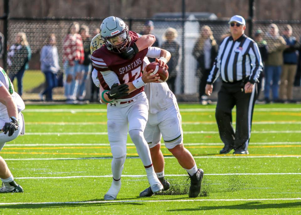 Stang quarterback Noah Grigson is sacked by Bishop Feehan's defensive linemen Tristan Upton.