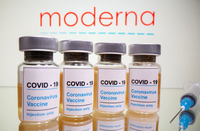 FILE PHOTO: FILE PHOTO: Vials and medical syringe are seen in front of Moderna logo in this illustration
