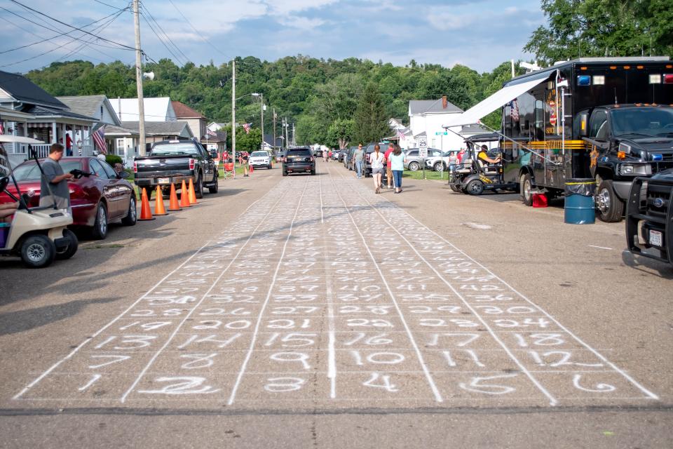 A horse-dropping bingo board breaks up the road in Quaker City for the Ohio Hill Folk Festival. One of the parade highlights, the festival also offered live music, food vendors, carnival rides a quilt show and more.