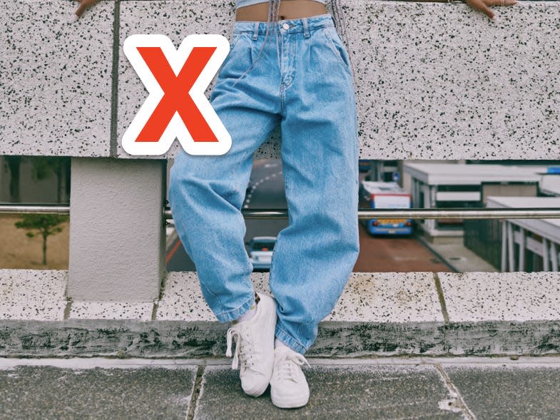 red x over person wearing baggy blue jeans and white sneakers