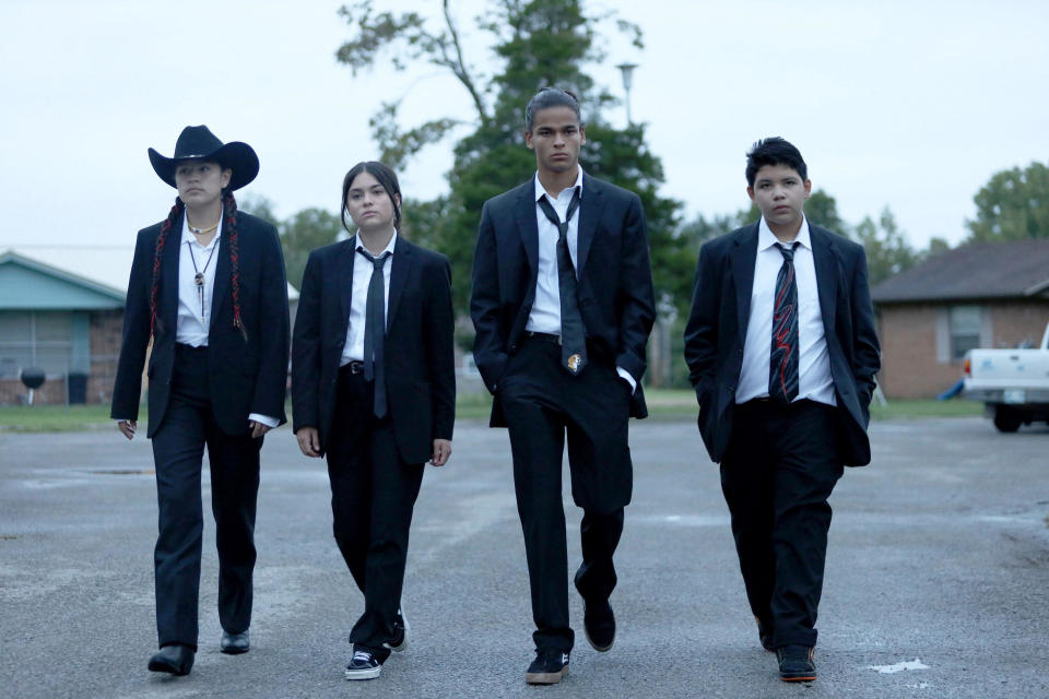 The group walking in matching suits and ties