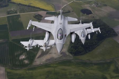 Norway's Air Force F-16 fighters (R) and Italy's Air Force Eurofighter Typhoon fighters patrol over the Baltics during a NATO air policing mission from Zokniai air base near Siauliai, Lithuania, May 20, 2015. REUTERS/Ints Kalnins/File Photo