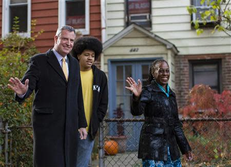 New York City mayor-elect Bill de Blasio (L) waves as he exits his home with his son Dante and his wife Chirlane McCray in the Park Slope section of the Brooklyn borough in New York, November 5, 2013. REUTERS/Brendan McDermid