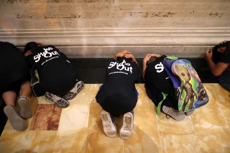 Children practice sheltering during an earthquake drill during the annual California ShakeOut in Los Angeles, California, U.S. October 19, 2017. REUTERS/Lucy Nicholson