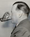 <p>The famous singer and composer, Wishart Campbell, is seen smoking a pipe in 1956 with his pet owl, Archie, perched on top. </p>