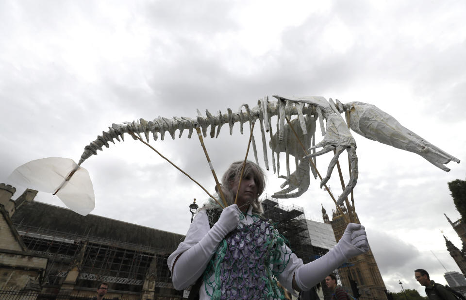 A protestor carries a pretend skeleton near Parliament in London, Tuesday, Oct. 8, 2019. Police are reporting they have arrested more than 300 people at the start of two weeks of protests as the Extinction Rebellion group attempts to draw attention to global warming. (AP Photo/Kirsty Wigglesworth)