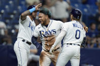 Tampa Bay Rays' Harold Ramirez, center, celebrates with David Peralta, left, and Taylor Walls on a two-run single by Randy Arozarena off Kansas City Royals starting pitcher Brady Singer during the sixth inning of a baseball game Friday, Aug. 19, 2022, in St. Petersburg, Fla. (AP Photo/Chris O'Meara)