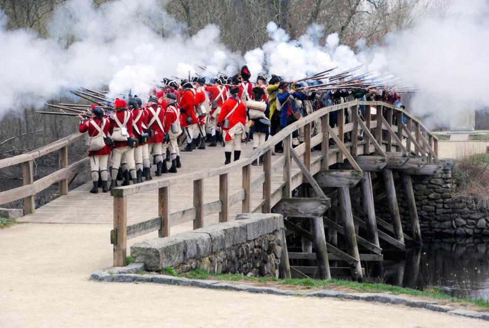 a group of people in red uniforms standing on a bridge with smoke