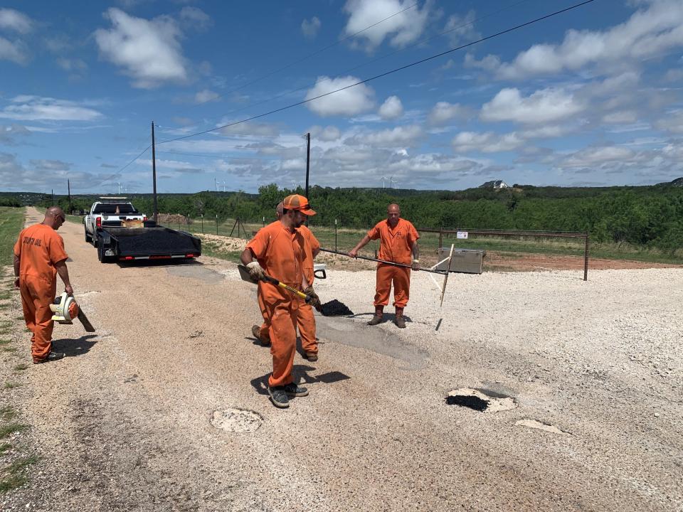 Inmates from the Taylor County Jail fix potholes in county roads as part of the roadworks team on June 18.