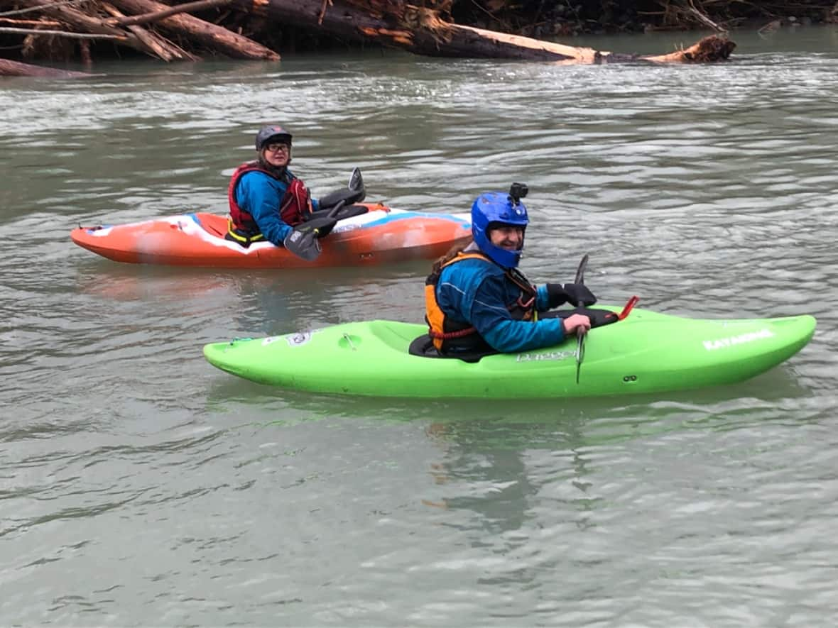 Ky Konojaki, in the front with a blue helmet, led a team of kayakers to help deliver supplies to Suzy Coulter, whose farm had been cut off from the main road due to floods last month in Chilliwack, B.C.  (Submitted by Suzy Coulter - image credit)