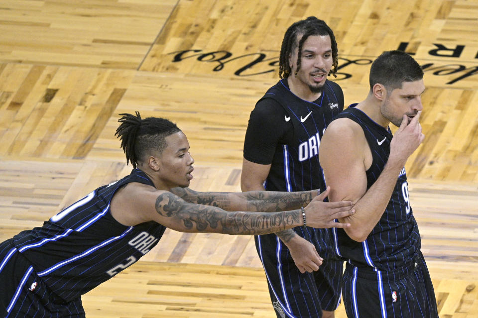 Orlando Magic guards Markelle Fultz (20) and Cole Anthony hold back center Nikola Vucevic (9) after he was called for a technical foul during the first half of the team's NBA basketball game against the Philadelphia 76ers, Thursday, Dec. 31, 2020, in Orlando, Fla. (AP Photo/Phelan M. Ebenhack)