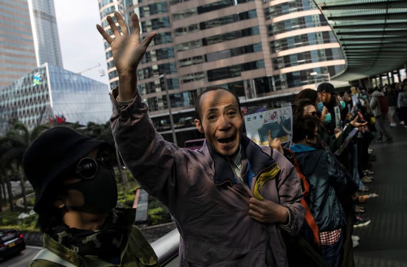 A man shouts slogans as office workers attend a lunch time protest on a pedestrain bridge in Hong Kong