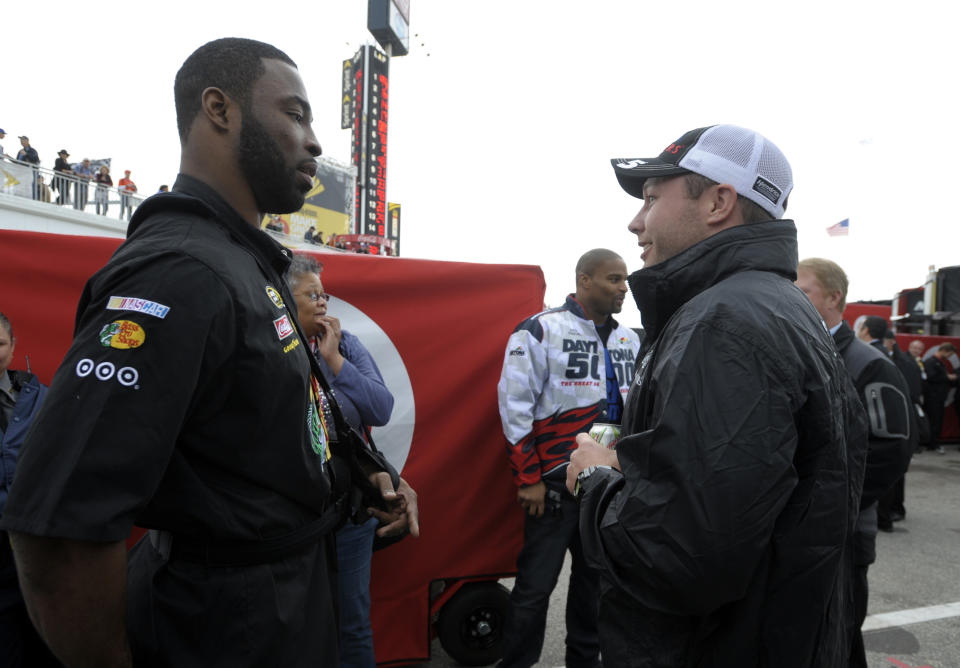 New York Giants NFL football defensive linemen Justin Tuck, left, talks with Jared Erspamer, of Omaha, Neb., while walking through the garage area with teammate Osi Umenyiora, rear center, prior to the NASCAR Daytona 500 Sprint Cup series auto race at Daytona International Speedway in Daytona Beach, Fla., Sunday, Feb. 26, 2012. (AP Photo/Phelan M. Ebenhack)