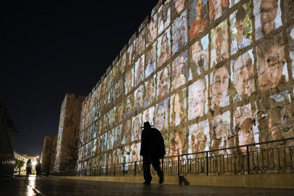 FILE - Photographs of Israeli hostages being held by Hamas militants are projected on the walls of Jerusalem's Old City, on Nov. 6, 2023. Fears are rising that time is running out for hostages in Gaza that are still alive. Nearly eight months later, there are 43 hostages whose remains are being held by Gaza militants and roughly 80 who have not been declared dead. (AP Photo/Leo Correa, File)