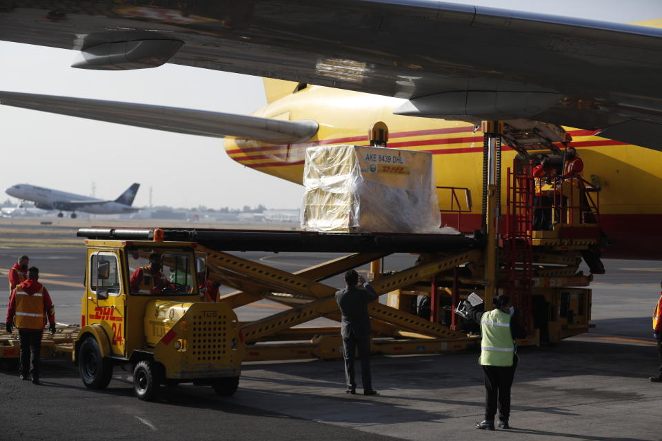 FILE - In this Dec. 23, 2020, file photo, the first shipment of the Pfizer COVID-19 vaccine is unloaded from a DHL cargo plane at the Benito Juarez International Airport in Mexico City. Countries including Serbia, Bangladesh and Mexico recently began vaccinating citizens through donations or commercial deals — an approach that could leave even fewer vaccines for the program known as COVAX, since rich countries have already snapped up the majority of this year's supply. (AP Photo/Eduardo Verdugo, File)