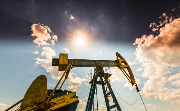 An oil pump with a sunny sky in the background.