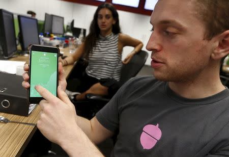 Ali Malek, an employee of U.S.-based technology company Acorns, demonstrates their smartphone-based app at the organization's Sydney headquarters in Australia, April 19, 2016. REUTERS/Jason Reed