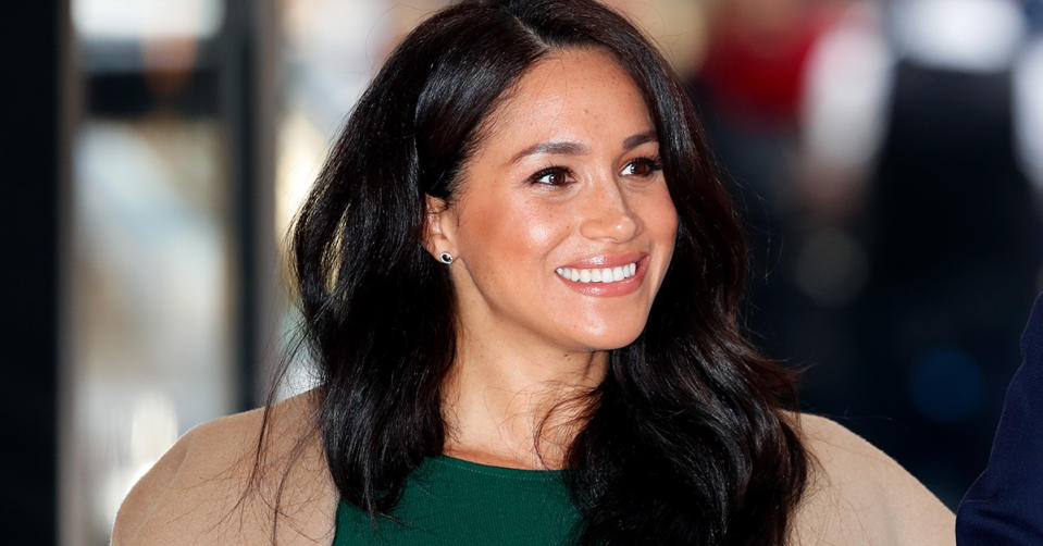 Meghan Markle wearing a green dress smiling