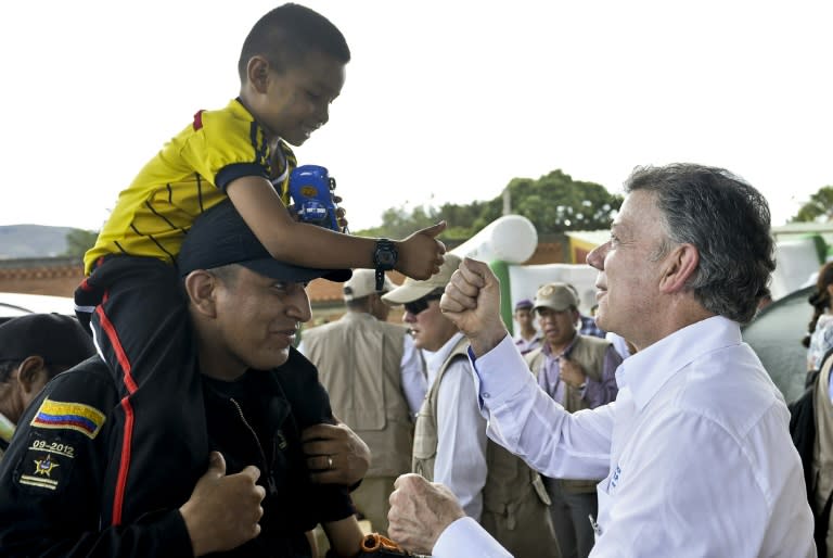 Photo released by the presidential press office showing Colombian President Juan Manuel Santos (R) during a visit to a shelters in Villa del Rosario, Colombia, where Colombians deported by Venezuelan authorities are lodged on August 29, 2015