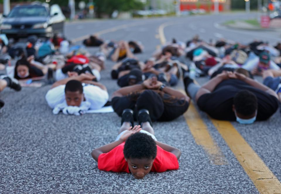 Six-year-old Blue Scott, of Florissant, Mo.,assumes a prone position on Sunday, June 7, 2020, as he participates with about 100 protesters in a die-in in the middle of Lindbergh Boulevard in front of the Florissant Police Station in Florissant, Mo. A suburban St. Louis police detective has been suspended after a video appears to show him hitting a man with a police SUV and then hitting the suspect at least twice while arresting him. Florissant Police Chief Tim Fagan has asked St. Louis County police and the FBI to investigate. (Christian Gooden/St. Louis Post-Dispatch via AP)