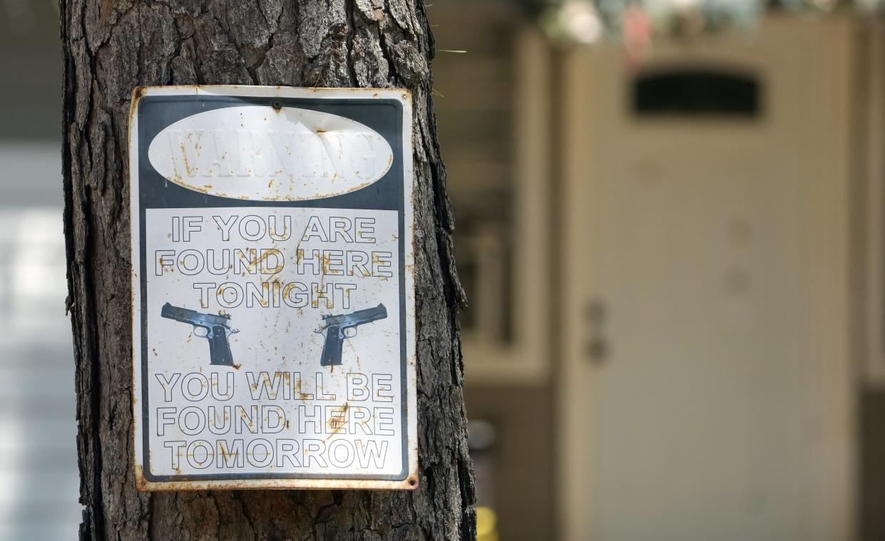 A warning sign is seen Sunday, April 30, 2023, outside the home where a mass shooting occurred Friday night, in Cleveland, Texas. The search for a man who allegedly shot his neighbors after they asked him to stop firing off rounds in his yard stretched into a second day Sunday, with authorities saying the man could be anywhere by now. Francisco Oropeza, 38, fled after the shooting Friday night that left several people dead, including an 8-year-old boy. (AP Photo/David J. Phillip)
