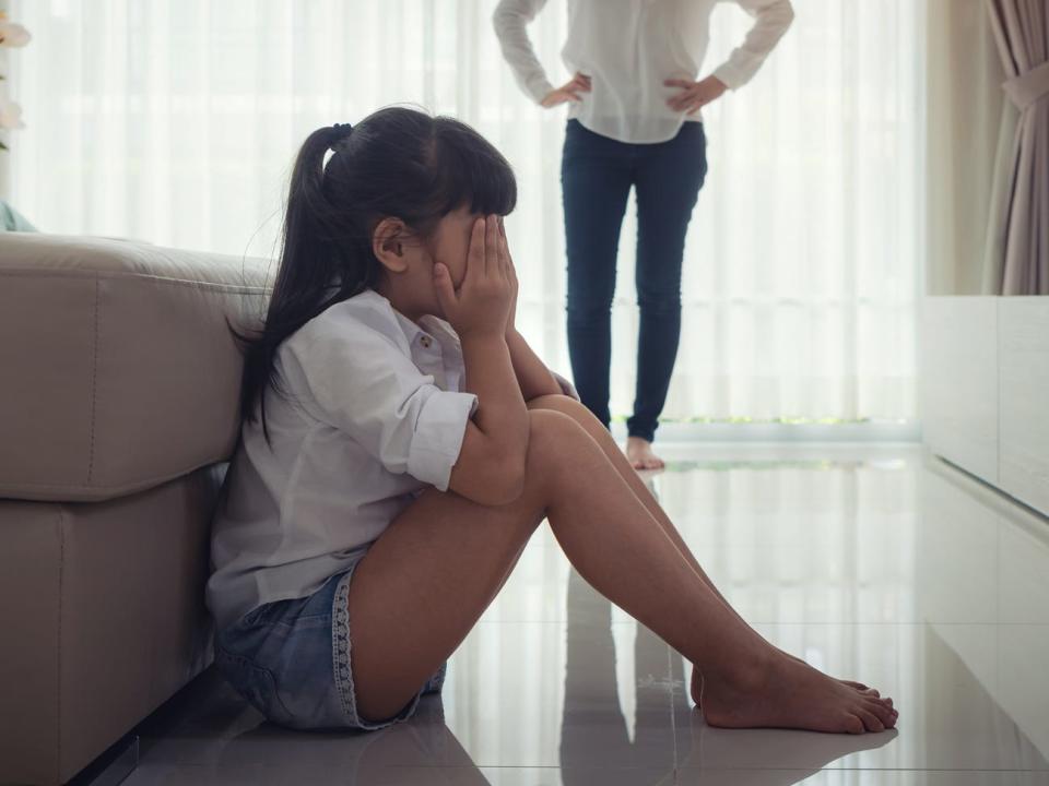 A young girl crying in front of her mom