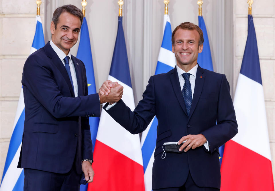 Greek Prime Minister Kyriakos Mitsotakis, left, and French President Emmanuel Macron shake hands after the signing of a new defense deal at The Elysee Palace Tuesday, Sept. 28, 2021 in Paris. France and Greece announced on Tuesday a major, multibillion-euro defense deal including Athens' decision to buy three French warships. (Ludovic Marin, Pool Photo via AP)