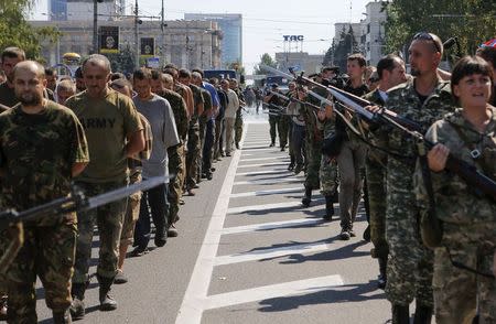 Armed pro-Russian separatists (R) escort a column of Ukrainian prisoners of war as they walk across the centre of Donetsk August 24, 2014. REUTERS/Maxim Shemetov