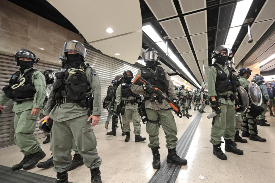 Riot police form a line at a shopping mall in Hong Kong, Sunday, Nov. 3, 2019. Riot police stormed several malls in Hong Kong on Sunday in a move to thwart more pro-democracy protests, as the city's leader heads to Beijing for talks on deepening economic integration between the semi-autonomous Chinese territory and mainland China. (AP Photo/Dita Alangkara)