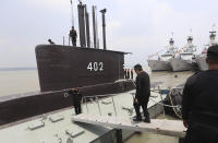 The crew of the Indonesian Navy submarine KRI Nanggala salute as an officer walks aboard at the base of the Eastern Fleet Command in Surabaya, East Java, Indonesia, in this Friday, Dec. 5, 2014 photo. Indonesia's navy is searching for the KRI Nanggala submarine that went missing north of the resort island of Bali with a number of people on board, the military said Wednesday, April 21, 2021. (AP Photo)