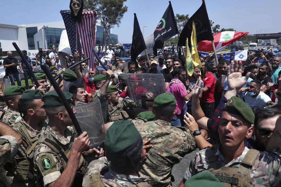 Hezbollah supporters scuffle with Lebanese army soldiers while protesting the visit by Gen. Frank McKenzie, the head of U.S. Central Command, outside ​​the Rafik Hariri International Airport in Beirut, Lebanon, Wednesday, July 8, 2020. (AP Photo/Bilal Hussein)