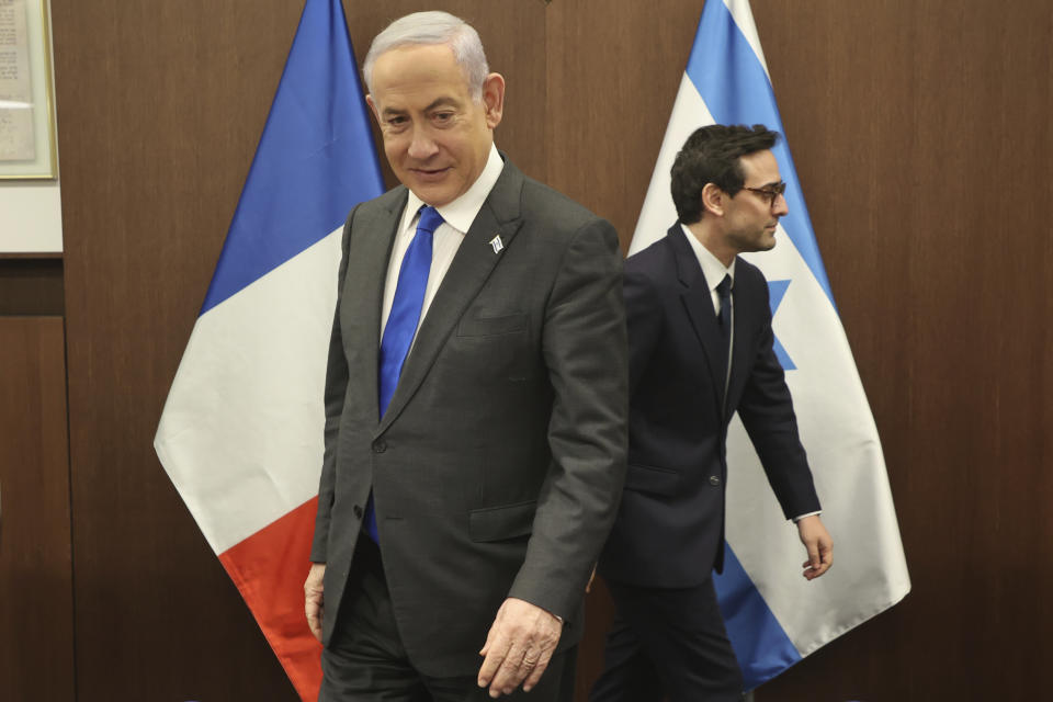 Israeli Prime Minister Benjamin Netanyahu, left, takes a seat before his meeting with France's Foreign Minister Stephane Sejourne, right, in Jerusalem Monday, Feb. 5, 2024. 5, 2024. (Gil Cohen-Magen/Pool via AP)
