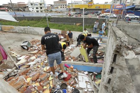 Police officers search through debris after an earthquake struck off Ecuador's Pacific coast, at Tarqui neighborhood in Manta April 17, 2016. REUTERS/Guillermo Granja
