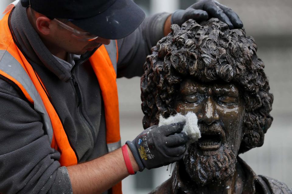 Chris Mahony of P.Mac Cleaning and Restoration services wipes the statue (PA)