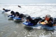 Senior women gather to boogie board on International Women's Day in Solana Beach, California