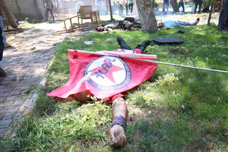 A victim, with a flag of the left-wing Federation of Socialist Youth Associations covering him, lies on the ground following an explosion in Suruc, in the southeastern Sanliurfa province, Turkey, July 20, 2015. REUTERS/Ozcan Soysal/Depo Photos