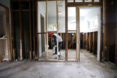 A man works in his flood-damaged house in the aftermath of Tropical Storm Harvey in Port Arthur, Texas, U.S. September 5, 2017. REUTERS/Jonathan Bachman