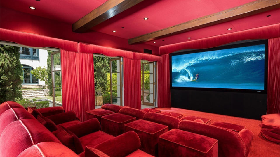 The lush home theater decked out in a bold red color. - Credit: Redfin