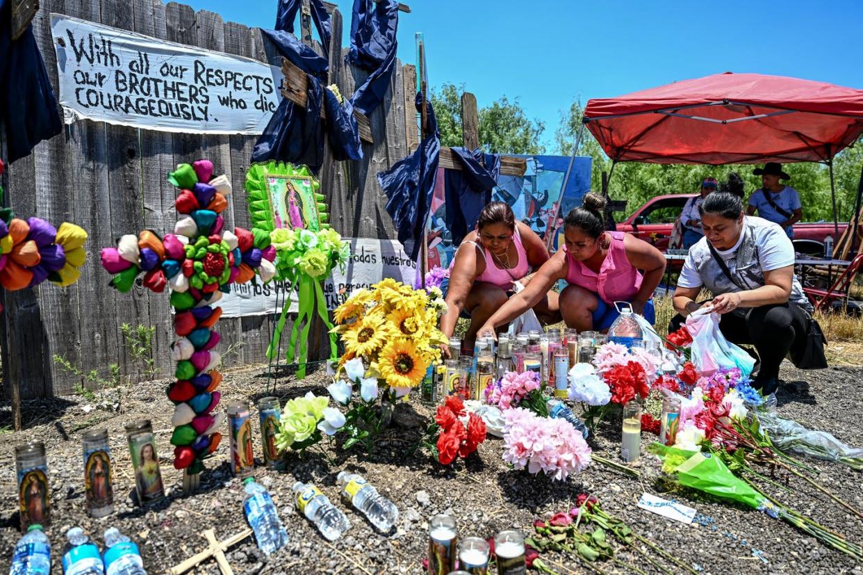 A makeshift memorial where a tractor-trailer was discovered with 53 dead migrants inside, near San Antonio, Texas, June 29, 2022. <a href="https://www.gettyimages.com/detail/news-photo/people-place-flowers-and-candles-at-a-makeshift-memorial-news-photo/1241612950?adppopup=true" rel="nofollow noopener" target="_blank" data-ylk="slk:Chandan Khanna/AFP via Getty Images;elm:context_link;itc:0;sec:content-canvas" class="link ">Chandan Khanna/AFP via Getty Images</a>