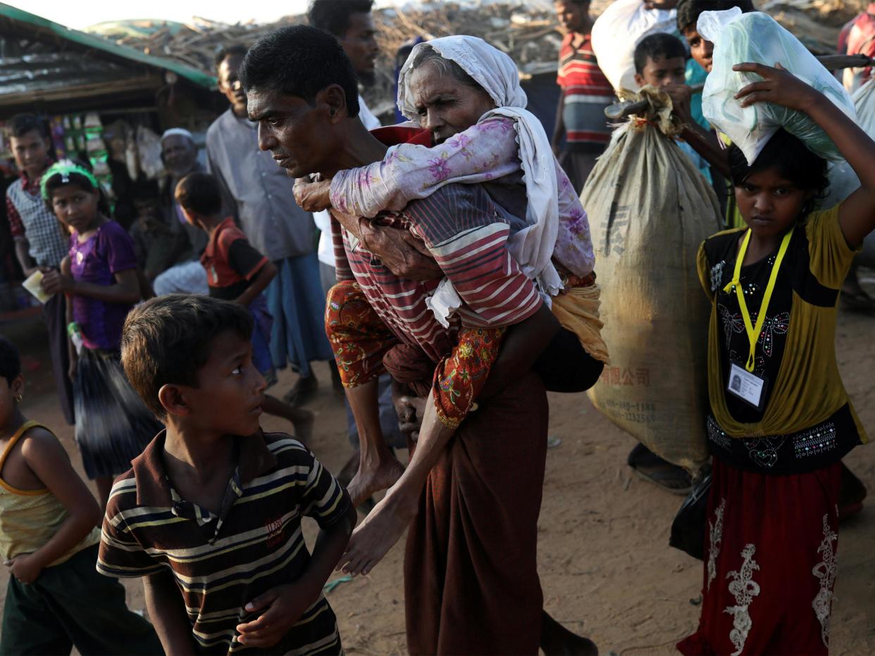 Rohingya refugee Suray Khatun, 70, is carried by her son Said-A-Lam, 38, as they enter Kutupalong refugee camp, near Cox's Bazar, Bangladesh a day after crossing the Myanmar border: REUTERS/Susana Vera