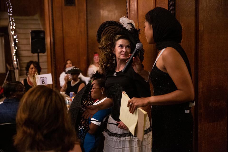 Janna Hellums is asked what her favorite piece of her outfit is by Christiana Gallagher, which was her hat, during the pageant portion of The Vintage Ball fundraiser event put on by the A Step Ahead Foundation of West Tennessee inside the New Southern Hotel on Thursday, September 8, 2022, in Jackson, Tennessee. During the pageant, women who were asked to participate stood up and walked through the room to show off their vintage outfits before judges picked a winner. The event was an opportunity for women to come together dressed in their vintage attire while raising money for the foundation. 