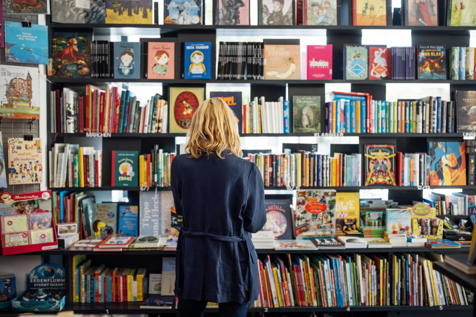 A person standing in a book store looking at children's books