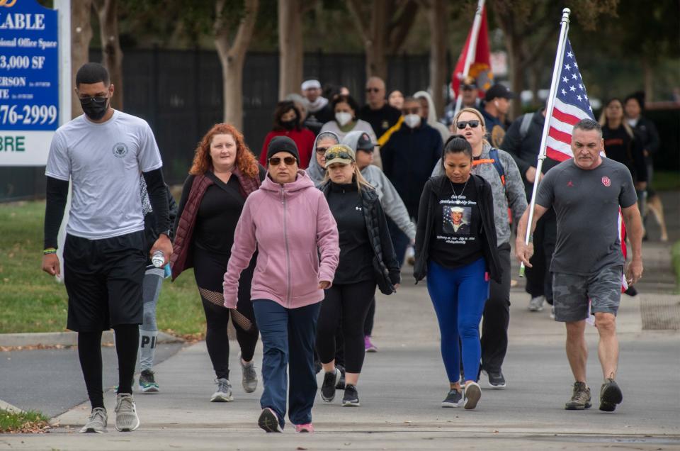 A group of about 30 people walk down Shadowbrook Drive in Stockton during the 9 Miles for 9 Heroes walk in Stockton. The walk remembers Navy corpsman Christopher "Bobby" Gnem of Stockton, who was killed in a training accident along with 8 Marines in Southern California.