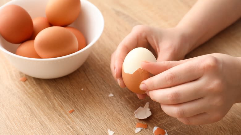 Hard-boiled eggs being peeled  