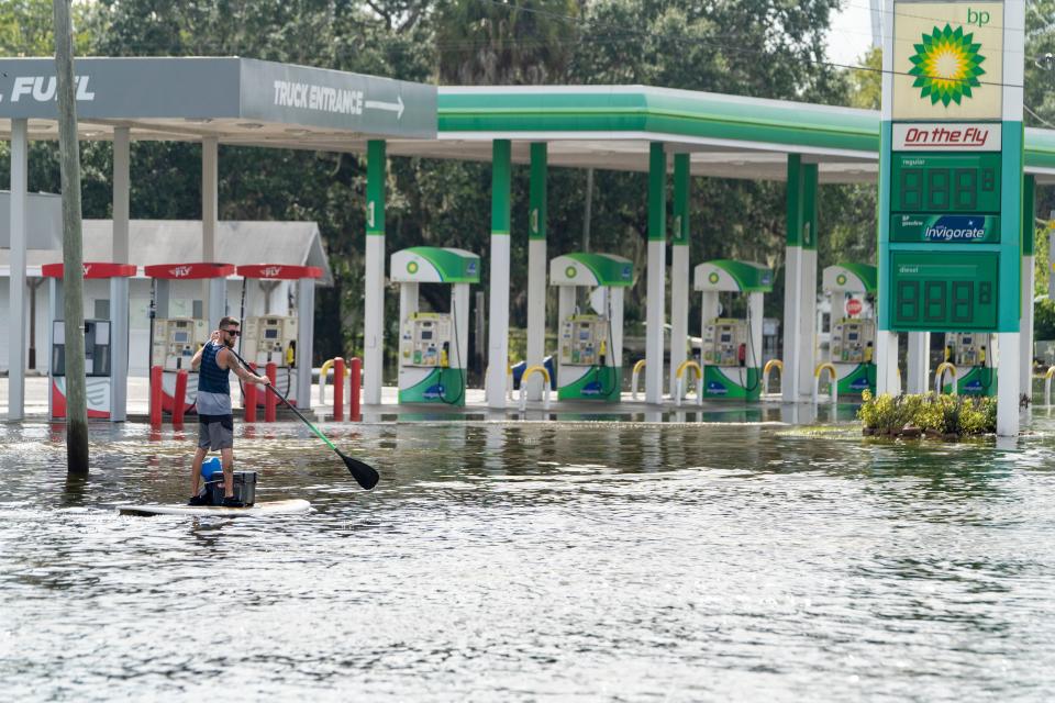 A man paddles through the flooded streets after Hurricane Idalia in Crystal River, Florida on August 30, 2023.