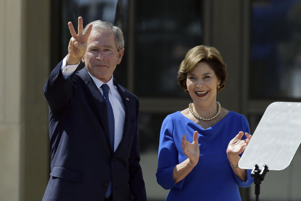 Former President George W. Bush, accompanied by his wife former first lady Laura Bush, flashes the "W" sign after his speech during the dedication of the George W. Bush presidential library on Thursday, April 25, 2013, in Dallas. (AP Photo/David J. Phillip)