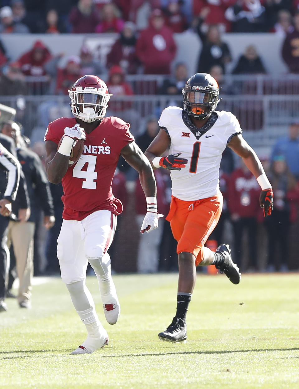 Oklahoma running back Trey Sermon (4) runs ahead of Oklahoma State linebacker Calvin Bundage (1) in the first quarter of an NCAA college football game in Norman, Okla., Saturday, Nov. 10, 2018. (AP Photo/Alonzo Adams)